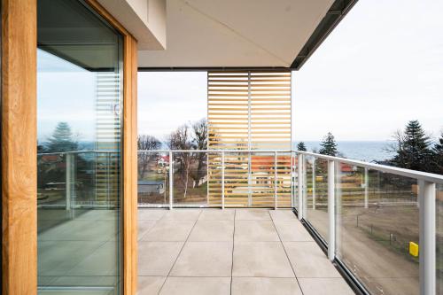 a glass balcony with a view of the ocean at ReVital Mechelinki by Homeprime Parking Free in Mechelinki
