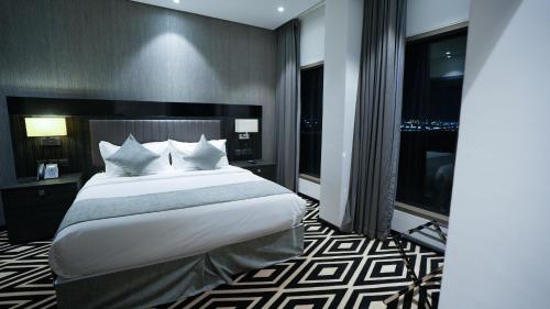 a bedroom with a large bed and a large window at Mirada Blue Falestine - Serviced Apartments in Jeddah