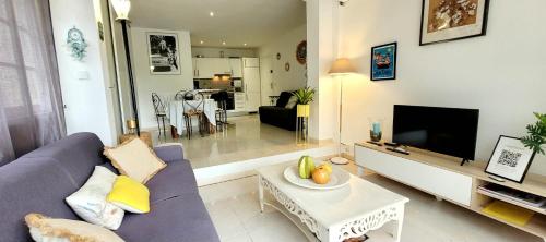 un salon avec un canapé violet et une télévision dans l'établissement Be Cool golfe de Saint-Tropez, à Saint-Tropez