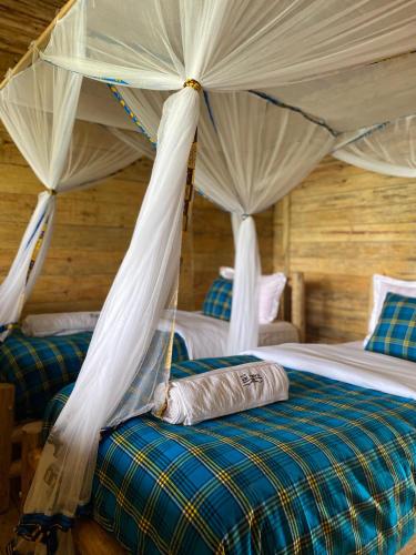 a bedroom with two beds with mosquito nets at Nyanja View Resort in Fort Portal