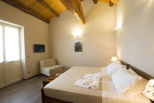 a bedroom with a bed and a chair and a window at Ca'Rapulin in Calosso