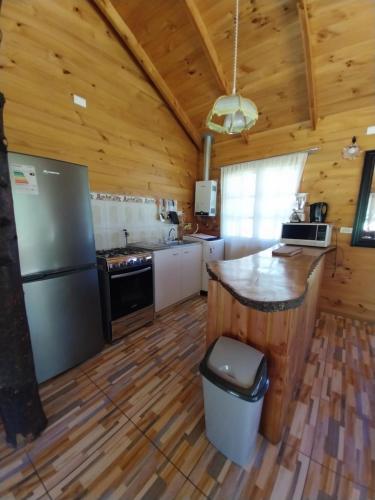 a kitchen in a log cabin with a counter at Amanecer de Caburgua in Pucón
