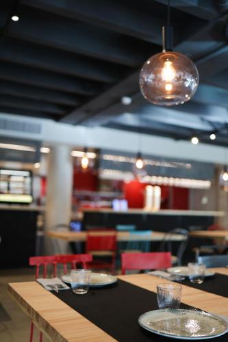 a restaurant with tables and chairs with plates and glasses at KY Mountain Hostel Arinsal in Arinsal
