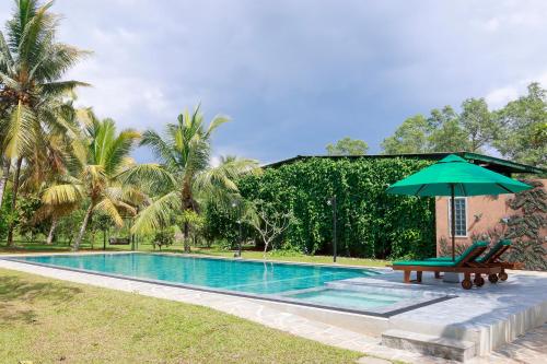 a swimming pool with a bench and an umbrella at Green Hideaway - Villa with Private Pool, 8 mins to Galle Fort in Galle