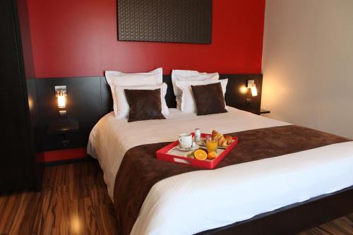 a hotel room with a bed with a tray of fruit on it at Best Western Park Hotel Geneve-Thoiry in Thoiry