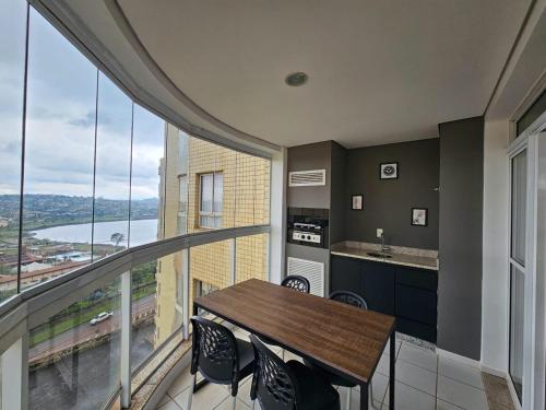 a kitchen with a table and chairs and a balcony at Lindo AP com vista para a Lagoa dos Ingleses in Nova Lima