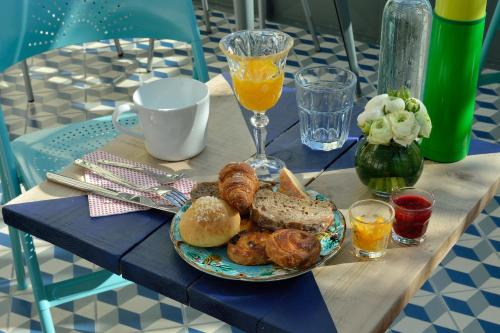 a table with a plate of pastries and a glass of orange juice at B&B Villa Du Roc Fleuri in Cannes