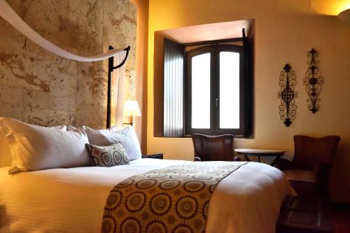 a hotel room with a bed and a window at Hodelpa Nicolás de Ovando in Santo Domingo