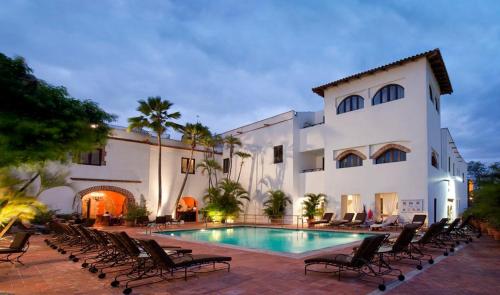 a pool in front of a building with chairs around it at Hodelpa Nicolás de Ovando in Santo Domingo