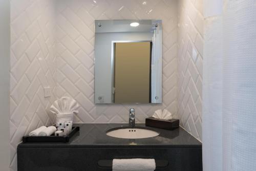 a bathroom with a sink and a mirror at Novus Plaza Hodelpa in Santo Domingo