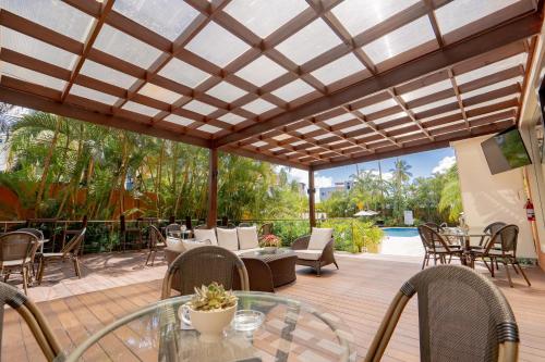 an outdoor patio with a glass table and chairs at Hodelpa Garden Court in Santiago de los Caballeros