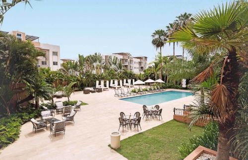 a resort with a pool and chairs and a resort at Hodelpa Garden Court in Santiago de los Caballeros