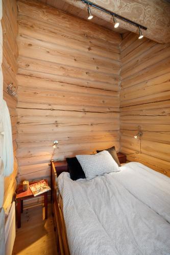 a bedroom with a bed in a wooden wall at Hytteperle Gålå, Vakre Lauvåsen, Hønhuset in Sør-Fron