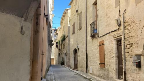 une allée entre deux bâtiments d'une vieille ville dans l'établissement Appartement jusqu'à 8, à Poussan