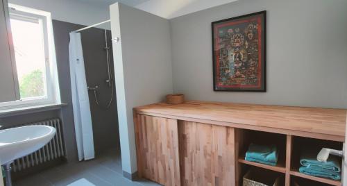 a bathroom with a wooden counter and a sink at Architektenhaus - Architect's House in Ebersberg