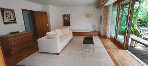 a living room with a white couch and a table at Architektenhaus - Architect's House in Ebersberg
