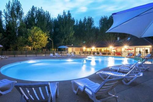 une grande piscine avec des chaises et un parasol dans l'établissement Camping 2 étoiles - Piscine - ccab0if, à Saint-Sozy