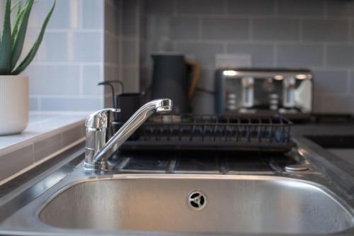 a kitchen sink with a metal strainer on it at Modern 3-Bed Home-Liverpool Stay in Sefton