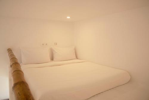 a small white room with a bed in it at Conch Resort Luxury Private Pool Suites in Puducherry