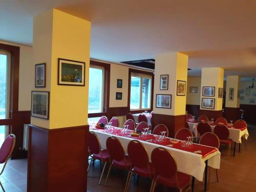 a dining room with a long table and chairs at Hotel Class in Brezoi
