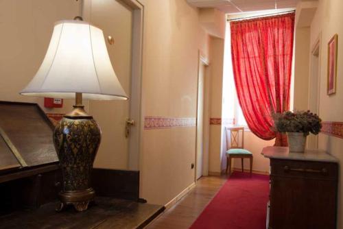 a room with a lamp and a door with a red curtain at Hotel Belle Epoque in Sanremo
