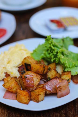 a plate of food with potatoes and broccoli on a table at Banana's Adventure Hostel in Ica