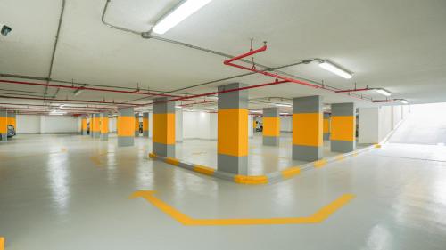 an empty parking lot with yellow and gray columns in a building at Mirada Blue Falestine - Serviced Apartments in Jeddah