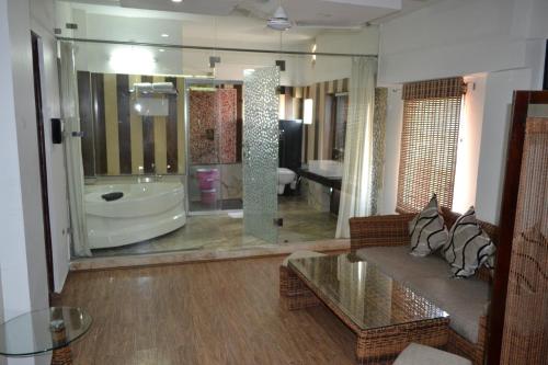 a living room with a large bathroom with a tub at Ganga Exotica in Haridwār