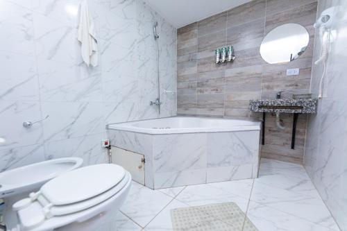 een witte badkamer met een bad en een toilet bij Ohana Apart Hotel in Termas de Río Hondo