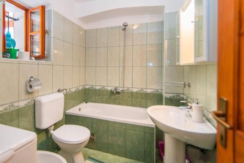 a bathroom with a toilet and a sink and a tub at VILLA CASTRA in Drivenik