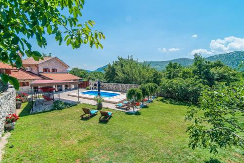 a yard with a swimming pool and a house at VILLA CASTRA in Drivenik