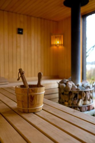 a wooden bucket with a hammer on top of a wooden table at Ezernams SPA in Kaukuri