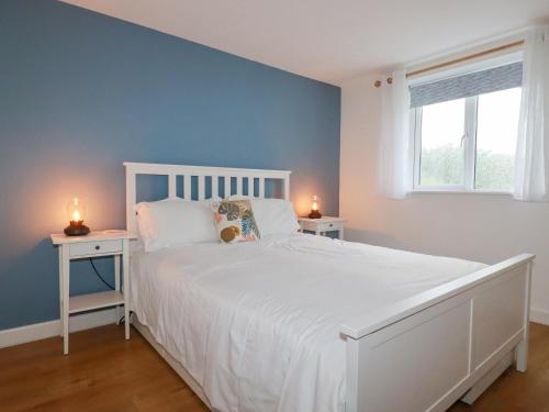 a bedroom with a white bed and two night stands at Apartment 6 in Newquay