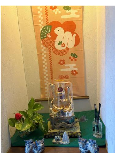 a table topped with a glass vase next to a plant at Tatami room & Living Room equipped with Multinational TV and Fire, BBQ corner in Tokyo Downtown House in Tokyo