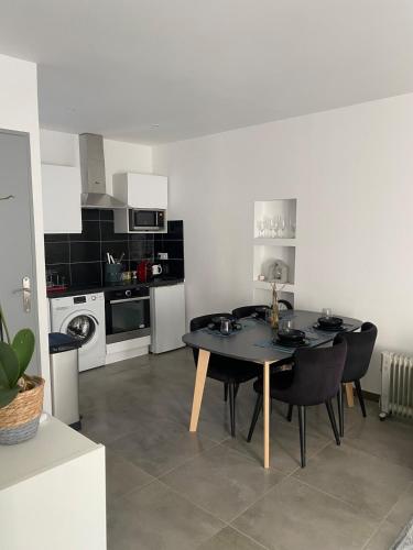 une cuisine avec une table et des chaises dans une pièce dans l'établissement Modern and Cosy Apartment, à Montpellier