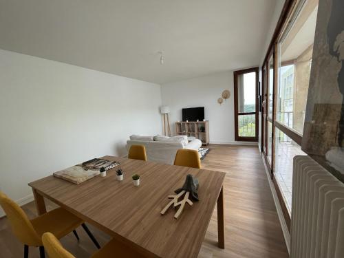 a living room with a wooden table and a couch at Le Familial in Orléans