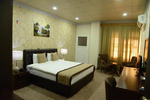 a hotel room with a bed and a desk at Diana Palace Hotel in Diyānah