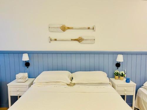 a bed in a room with two night stands and two lamps at Aurora do Campeche - Suíte Beira Mar in Florianópolis