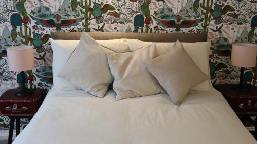 a white bed with pillows on it in a bedroom at Peterborough House in Saint Aubin