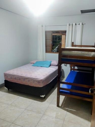 a small bedroom with a bed and a window at Recanto da Família in Quadra