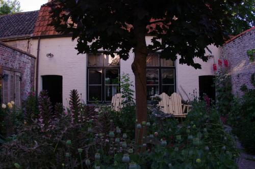 a garden with two chairs and a tree in front of a house at B&B Canal Deluxe in Bruges