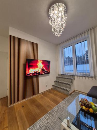 a living room with a television on a wall at Neubauwohnung mit 80 m2 Terrasse, 8 Minuten von Linz entfernt in Linz
