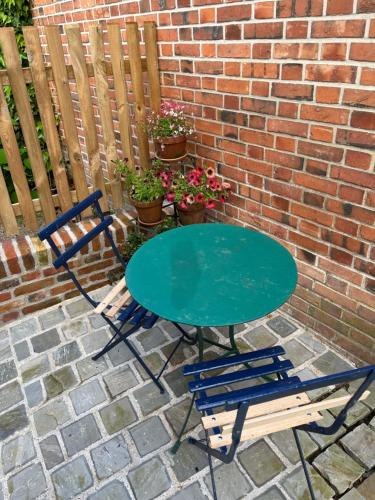 a table and two chairs sitting next to a brick wall at La petite maison in Souvigny-en-Sologne