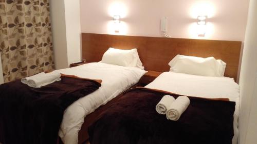 
a hotel room with two beds and two lamps at Martim Moniz 28 Guest House in Lisbon

