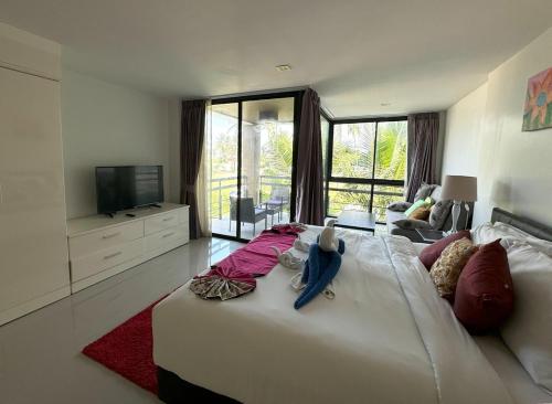 a large white bed in a living room with a television at Private apartment at Kris Condo by Lofty in Ban Lum Fuang