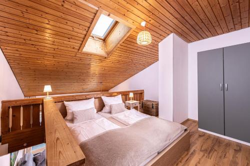 ein Schlafzimmer mit einem großen Bett und einer Holzdecke in der Unterkunft Haus Mitterbach Ferienwohnung Bergliebe in Berchtesgaden