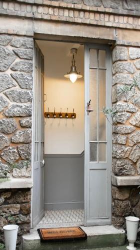 - une entrée pour un bâtiment en pierre avec une porte grise dans l'établissement Beautiful House Hyper Centre - 8 pers - Patio - Wifi, à Reims