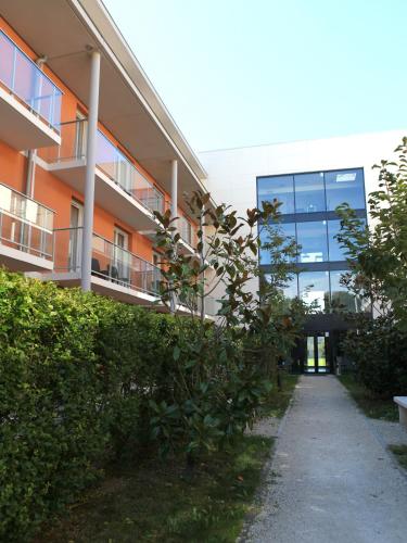 an apartment building with a walkway in front of it at Best Western Park Hotel Geneve-Thoiry in Thoiry