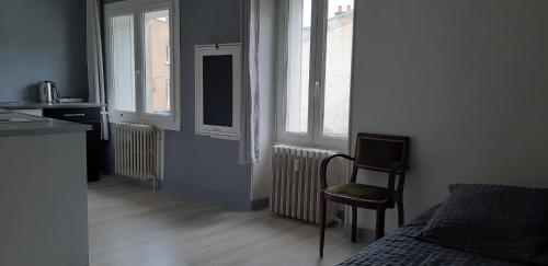 une chambre avec un lit, une chaise et des fenêtres dans l'établissement studio lumineux axe centre ville facs chu, à Poitiers
