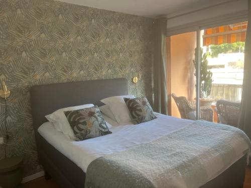 un lit avec deux oreillers dessus dans une chambre dans l'établissement Magnifique Appartement à Cassis,Parking,2 pas du Port, à Cassis